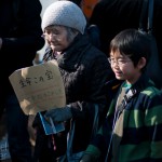 A grandmother carries a sign against nuclear power on March 11, 2012, in Tokyo, Japan.