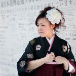 KANA INUI stops on her way to her graduation party to write her support for Japan on a wall on March 11, 2012 in downtown Tokyo.